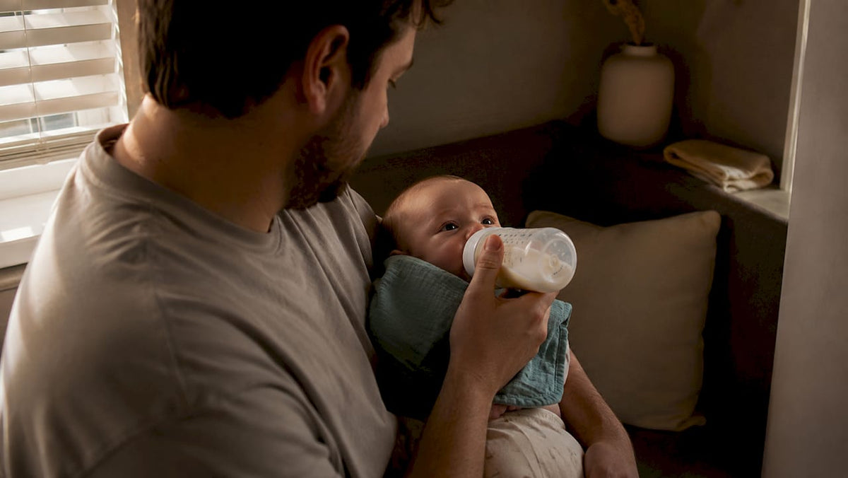 Parent practising paced bottle feeding upright