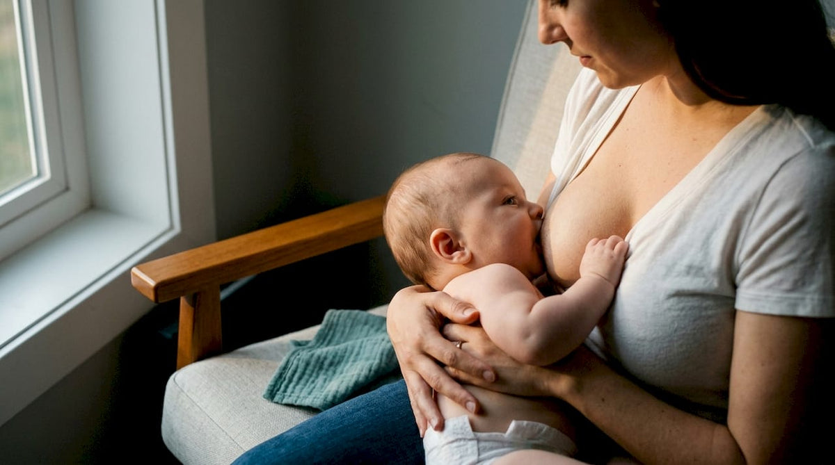 Mother aligning baby securely during feeding