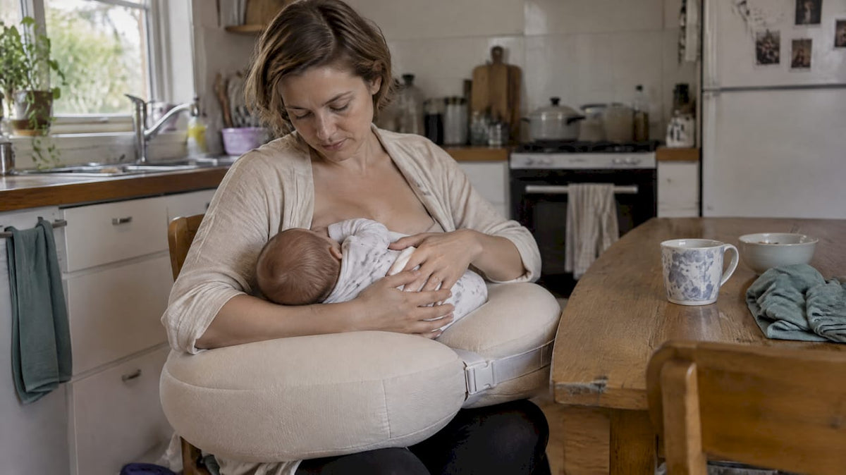 Mother breastfeeding with wrist-supporting nursing pillow