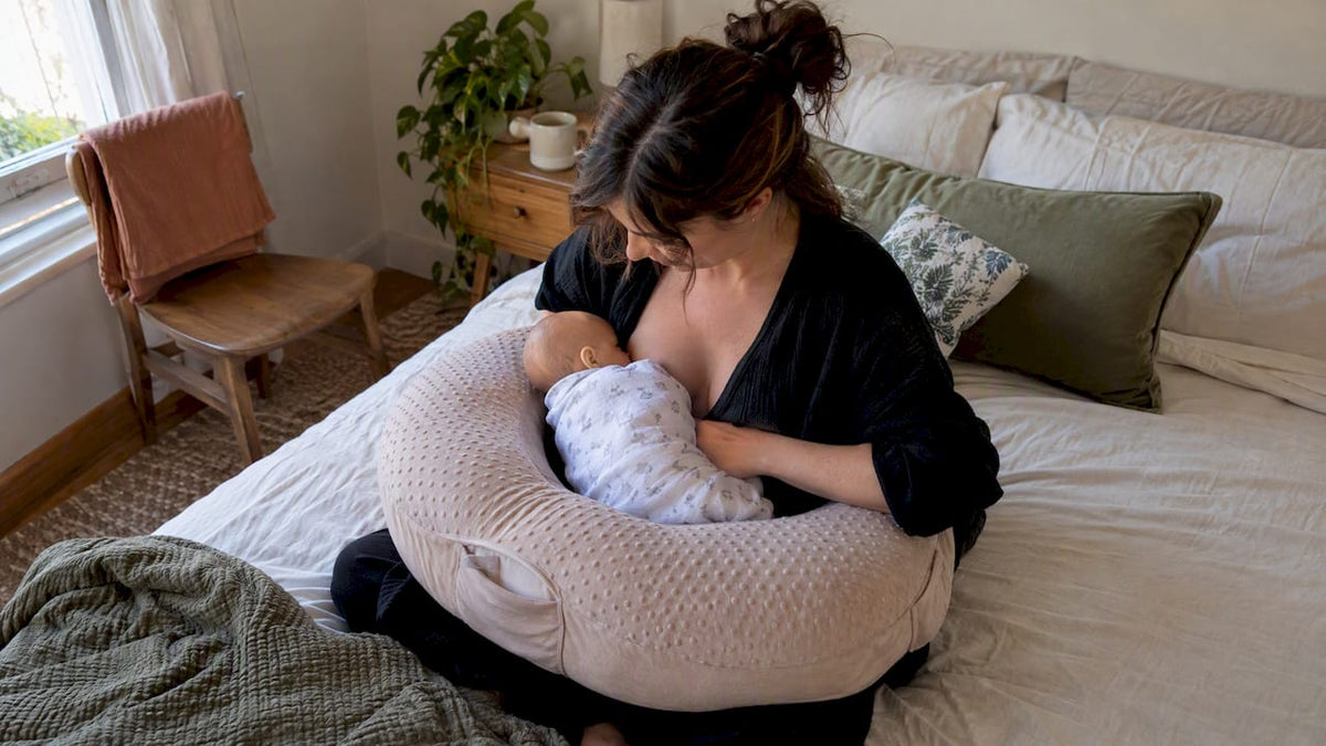 Mother nursing baby with elevated pillow